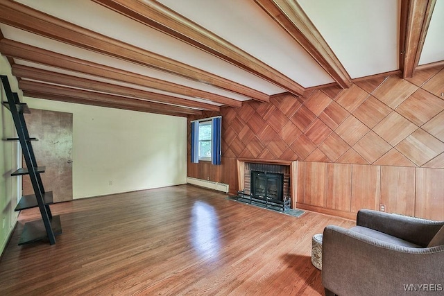425 Tryon Dr, Lewiston, NY 14092 - unfurnished living room featuring baseboard heating, a fireplace, wood finished floors, and beam ceiling