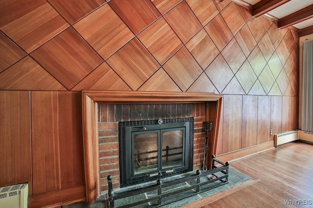 425 Tryon Dr, Lewiston, NY 14092 - detailed view of a brick fireplace, wooden walls, radiator, and wood finished floors