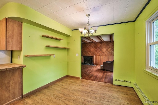 425 Tryon Dr, Lewiston, NY 14092 - unfurnished dining area featuring wood finished floors, a chandelier, a brick fireplace, and a baseboard radiator