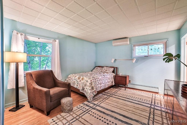 425 Tryon Dr, Lewiston, NY 14092 - bedroom with a baseboard radiator, an AC wall unit, and wood finished floors
