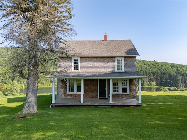 1870 Carey Rd, Franklin, NY 13775 - view of front facade featuring a chimney, a front lawn, a wooded view, roof with shingles, and a water view