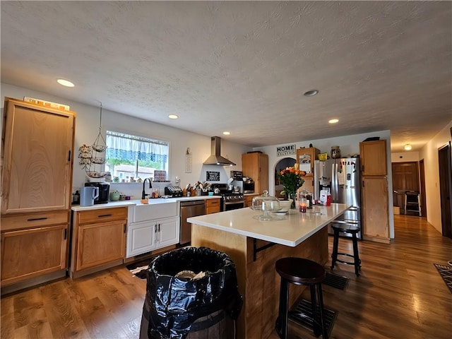 2313 Stickle Rd, Addison, NY 14801 - kitchen featuring wall chimney range hood, stainless steel appliances, a breakfast bar area, light countertops, and wood finished floors