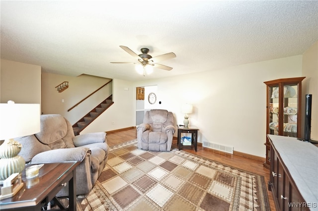 6193 New Taylor Rd, Orchard Park, NY 14127 - living room featuring stairs, a ceiling fan, and light wood-style flooring