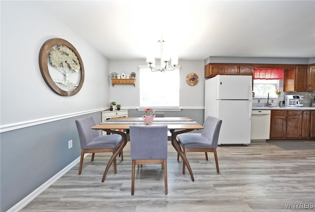 6193 New Taylor Rd, Orchard Park, NY 14127 - dining space with a chandelier and light wood-type flooring