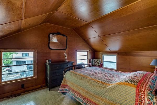 13 Mccabe Rd, Lisbon, NY 13669 - bedroom with lofted ceiling, light colored carpet, and wooden walls