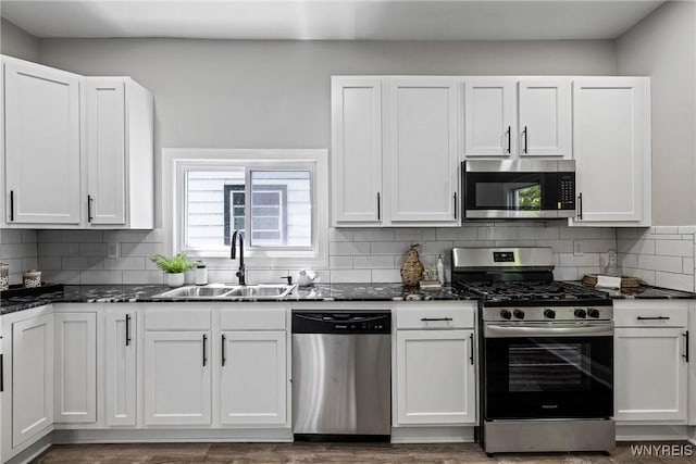 362 W Delavan Ave Unit N, Buffalo, NY 14213 - kitchen featuring stainless steel appliances, white cabinetry, decorative backsplash, dark stone countertops, and dark wood finished floors