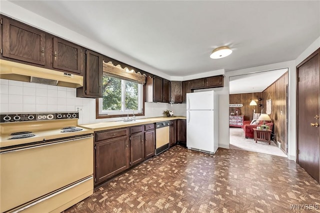 47 Brian Ave, Amherst, NY 14221 - kitchen with white appliances, under cabinet range hood, dark brown cabinets, wood walls, and light countertops