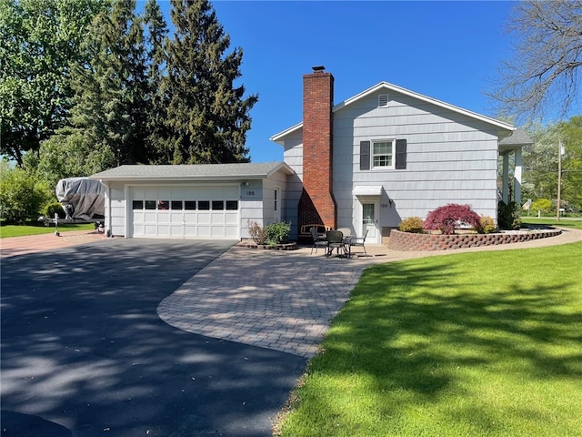 100 Huffer Rd, Parma, NY 14468 - view of front facade featuring a chimney, a front lawn, driveway, and a garage