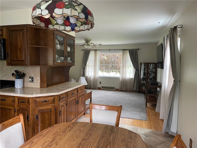 100 Huffer Rd, Parma, NY 14468 - kitchen with light countertops, ceiling fan, light wood finished floors, glass insert cabinets, and backsplash