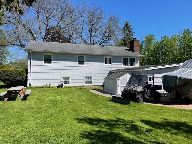 100 Huffer Rd, Parma, NY 14468 - back of house featuring a lawn, a chimney, roof with shingles, and a storage shed