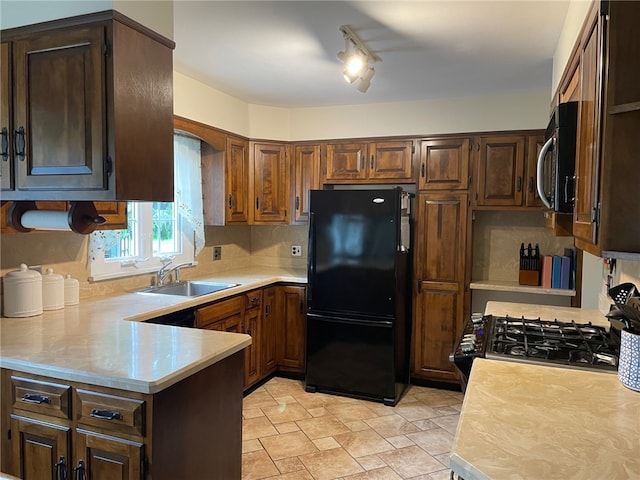 100 Huffer Rd, Parma, NY 14468 - kitchen with black appliances, light countertops, light stone finish flooring, a peninsula, and backsplash