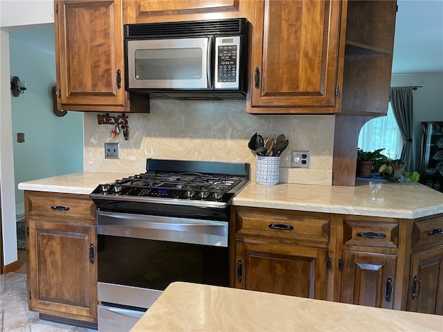 100 Huffer Rd, Parma, NY 14468 - kitchen with stainless steel range with gas cooktop, black microwave, tasteful backsplash, and light countertops