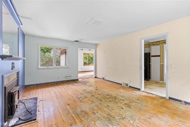 39 Scotch Ln, Irondequoit, NY 14617 - unfurnished living room featuring wood-type flooring and a wood stove
