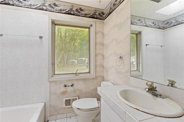 39 Scotch Ln, Irondequoit, NY 14617 - bathroom featuring a bathtub, vanity, and a skylight