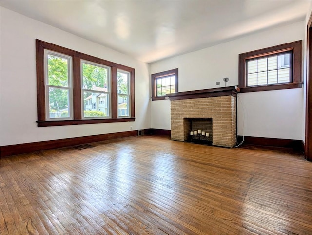 64 Saint Jacob St, Rochester, NY 14621 - unfurnished living room with hardwood / wood-style floors and a brick fireplace