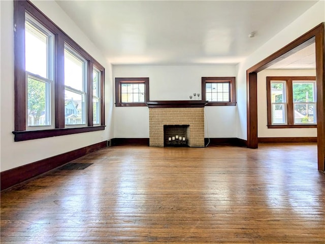 64 Saint Jacob St, Rochester, NY 14621 - unfurnished living room with healthy amount of natural light, hardwood / wood-style flooring, and a brick fireplace