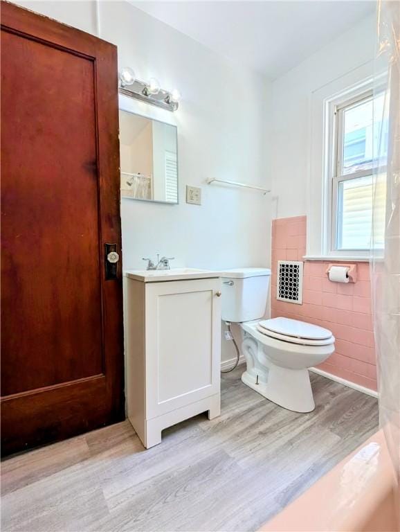 64 Saint Jacob St, Rochester, NY 14621 - bathroom featuring wood finished floors, tile walls, vanity, a wainscoted wall, and a shower