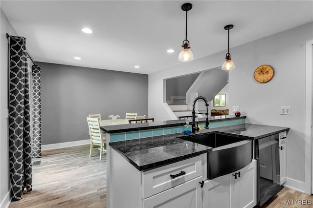 1202 Netherton Ct, Amherst, NY 14051 - kitchen with light wood-style flooring, white cabinetry, hanging light fixtures, dishwasher, and dark stone countertops
