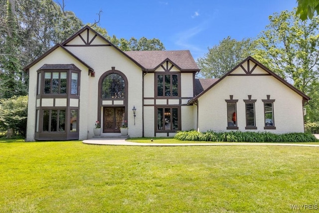 212 Crestwood Ln, Amherst, NY 14221 - tudor-style house with stucco siding, a front lawn, and a shingled roof