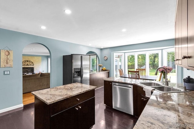 212 Crestwood Ln, Amherst, NY 14221 - kitchen featuring appliances with stainless steel finishes, arched walkways, light stone counters, recessed lighting, and plenty of natural light