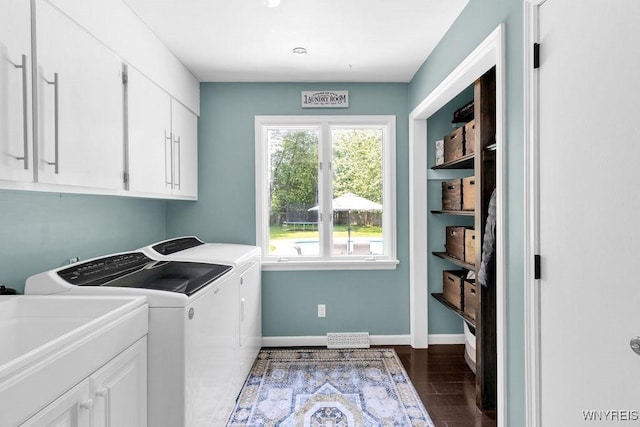 212 Crestwood Ln, Amherst, NY 14221 - washroom featuring washer and clothes dryer, cabinet space, and dark wood-type flooring