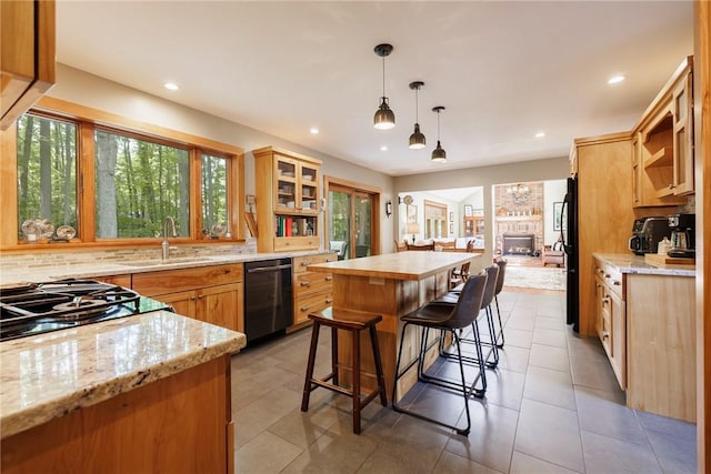 679 Galleon Dr, Webster, NY 14580 - kitchen featuring black appliances, a kitchen island, light stone counters, tasteful backsplash, and a kitchen breakfast bar