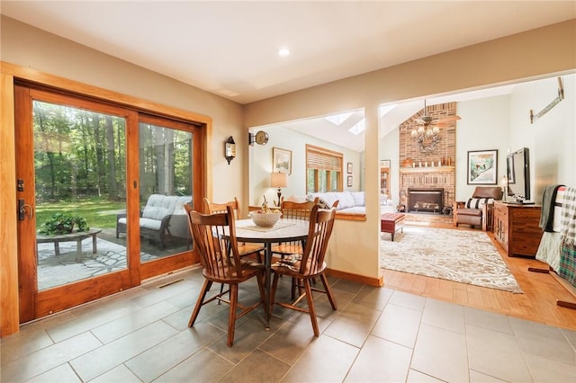679 Galleon Dr, Webster, NY 14580 - tiled dining room featuring healthy amount of natural light, a chandelier, a brick fireplace, lofted ceiling, and recessed lighting