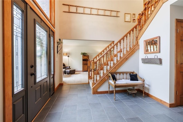 679 Galleon Dr, Webster, NY 14580 - entryway featuring plenty of natural light, stairs, a towering ceiling, and dark tile patterned flooring