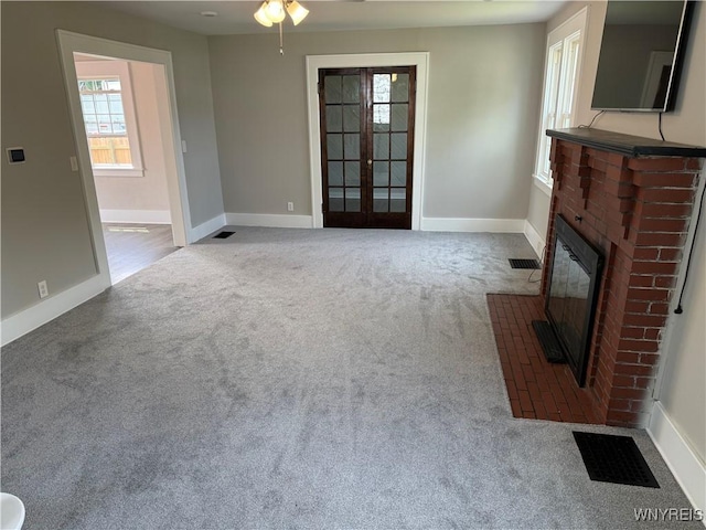 17 Orchard Ave, Evans, NY 14006 - unfurnished living room featuring carpet floors, french doors, a brick fireplace, and ceiling fan