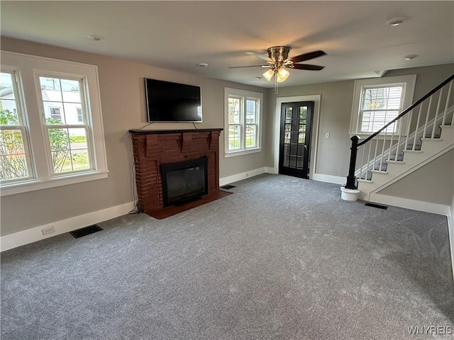 17 Orchard Ave, Evans, NY 14006 - unfurnished living room featuring healthy amount of natural light, carpet, stairs, and a brick fireplace