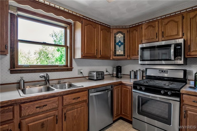 3851 Upper Mountain Rd, Cambria, NY 14132 - kitchen featuring stainless steel appliances, brown cabinetry, and light countertops