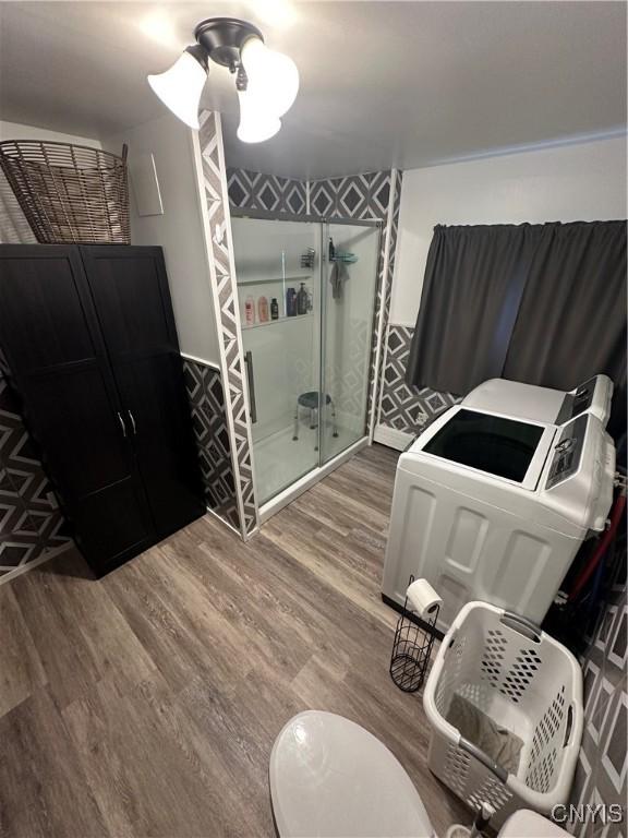 14309 Pearl St, Diana, NY 13648 - full bathroom featuring a stall shower, wood finished floors, and washing machine and dryer