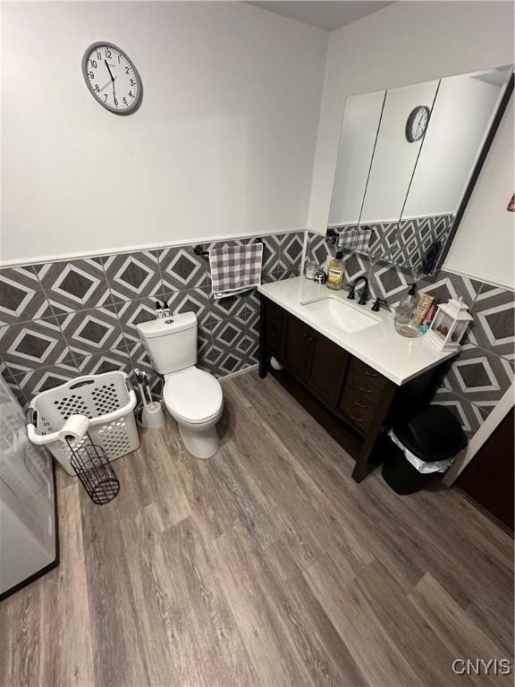 14309 Pearl St, Diana, NY 13648 - bathroom featuring wainscoting, wood finished floors, tile walls, and vanity