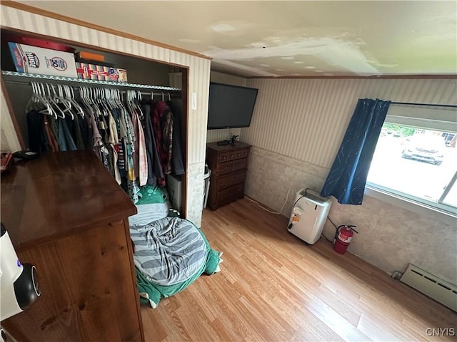 14309 Pearl St, Diana, NY 13648 - bedroom with a closet, wood finished floors, a baseboard radiator, and wallpapered walls