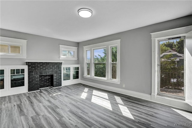 110 Weyand Ave, Buffalo, NY 14210 - unfurnished living room with wood finished floors, healthy amount of natural light, and a brick fireplace