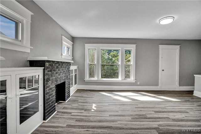 110 Weyand Ave, Buffalo, NY 14210 - unfurnished living room featuring plenty of natural light, wood finished floors, and a brick fireplace