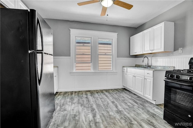 110 Weyand Ave, Buffalo, NY 14210 - kitchen with black appliances, wainscoting, a ceiling fan, light wood finished floors, and white cabinets