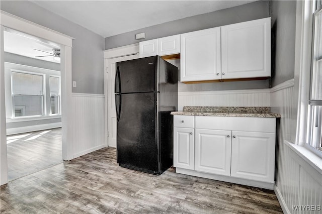 110 Weyand Ave, Buffalo, NY 14210 - kitchen with freestanding refrigerator, ceiling fan, wainscoting, white cabinets, and light wood-style flooring