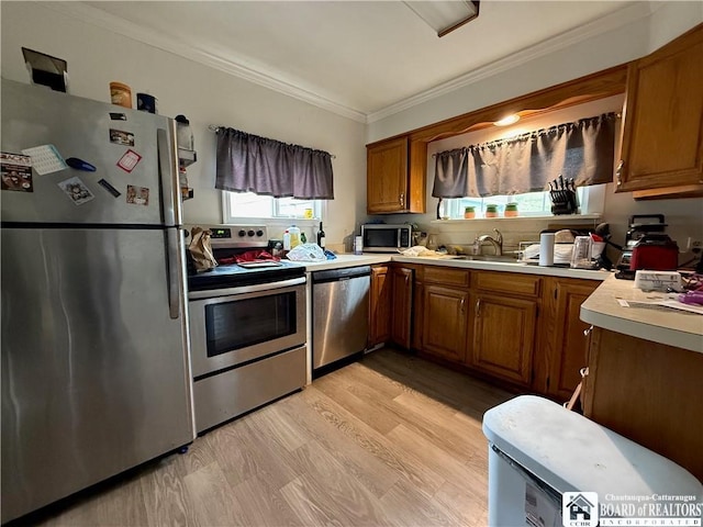 67 Harriet St, Allegany, NY 14706 - kitchen featuring appliances with stainless steel finishes, crown molding, brown cabinets, light countertops, and light wood-style floors