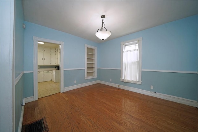 362 Euclid Ave, Elmira-City, NY 14905 - unfurnished room featuring built in shelves and wood finished floors