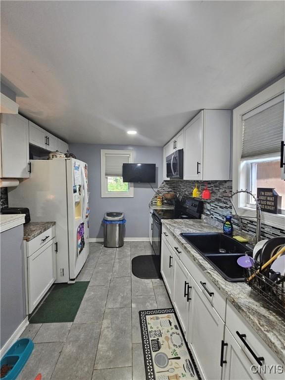 6 Bryant St, Utica, NY 13502 - kitchen with stainless steel microwave, electric range, and white cabinets