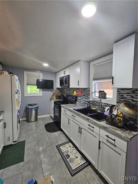 6 Bryant St, Utica, NY 13502 - kitchen featuring stainless steel microwave, black range with electric cooktop, white fridge with ice dispenser, and backsplash