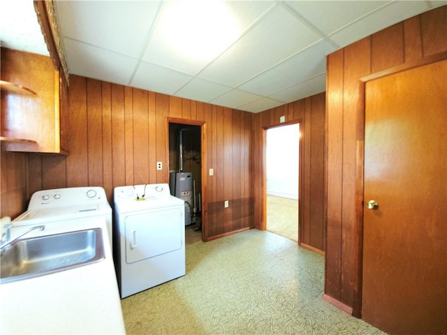 4883 Pinecrest Rd, Veteran, NY 14864 - laundry room featuring washing machine and clothes dryer, gas water heater, wood walls, cabinet space, and light floors