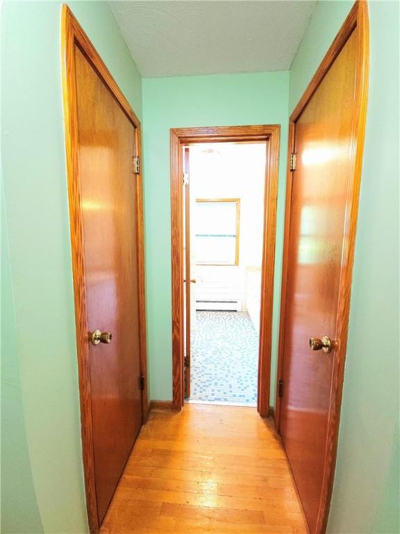 4883 Pinecrest Rd, Veteran, NY 14864 - hallway featuring baseboard heating and light wood-style floors