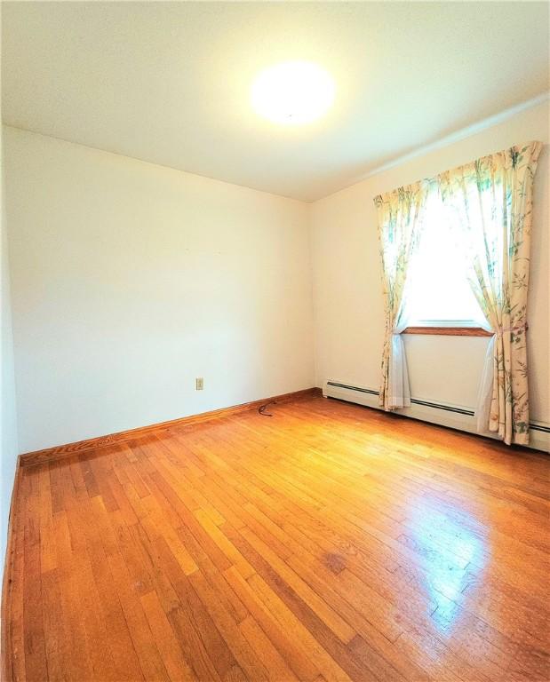 4883 Pinecrest Rd, Veteran, NY 14864 - spare room with light wood-type flooring and a baseboard radiator