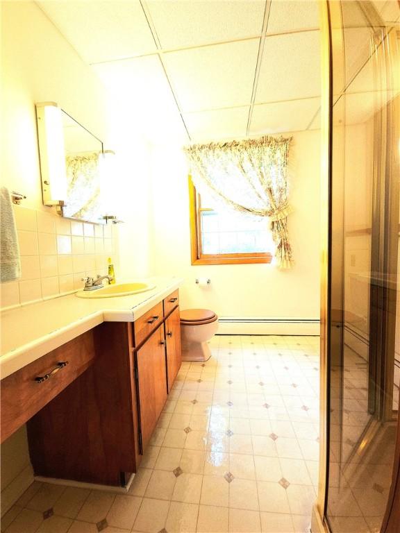 4883 Pinecrest Rd, Veteran, NY 14864 - bathroom with baseboard heating, a shower stall, vanity, backsplash, and a paneled ceiling