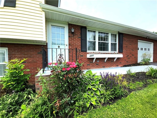 4883 Pinecrest Rd, Veteran, NY 14864 - view of exterior entry featuring an attached garage and brick siding