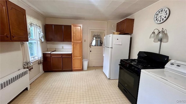 318 Boyden St, Syracuse, NY 13203 - kitchen with radiator, washer / dryer, black range with gas cooktop, freestanding refrigerator, and light countertops