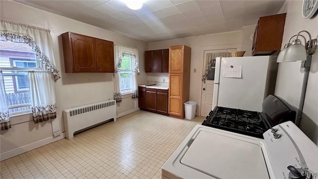 318 Boyden St, Syracuse, NY 13203 - kitchen with radiator heating unit, freestanding refrigerator, gas range oven, and light countertops