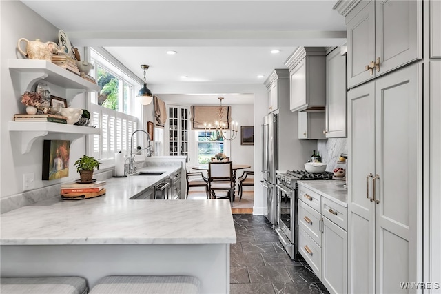 87 Garrison Rd, Amherst, NY 14221 - kitchen with premium appliances, open shelves, dark marble finish flooring, a peninsula, and a chandelier